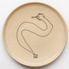 The mini talara necklace styled on a tan plate to show the adjustable lobster clasp closure