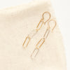 The mixed metal paperclip earrings styled on tan linen