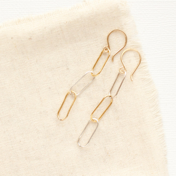 The mixed metal paperclip earrings styled on tan linen