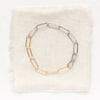 The mixed metal paperclip bracelet styled on tan linen