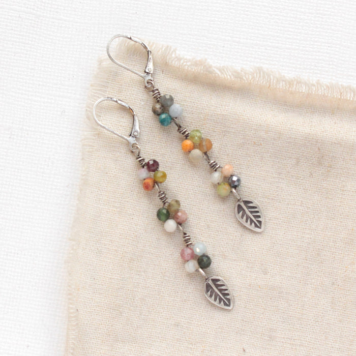 The kaleidoscope flowing leaf earrings styled on tan linen