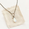 The moonstone and pearl necklace styled on tan linen