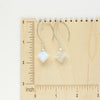 The moonstone slice earrings on a wooden ruler for size reference