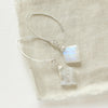 The moonstone slice petal earrings styled on tan linen