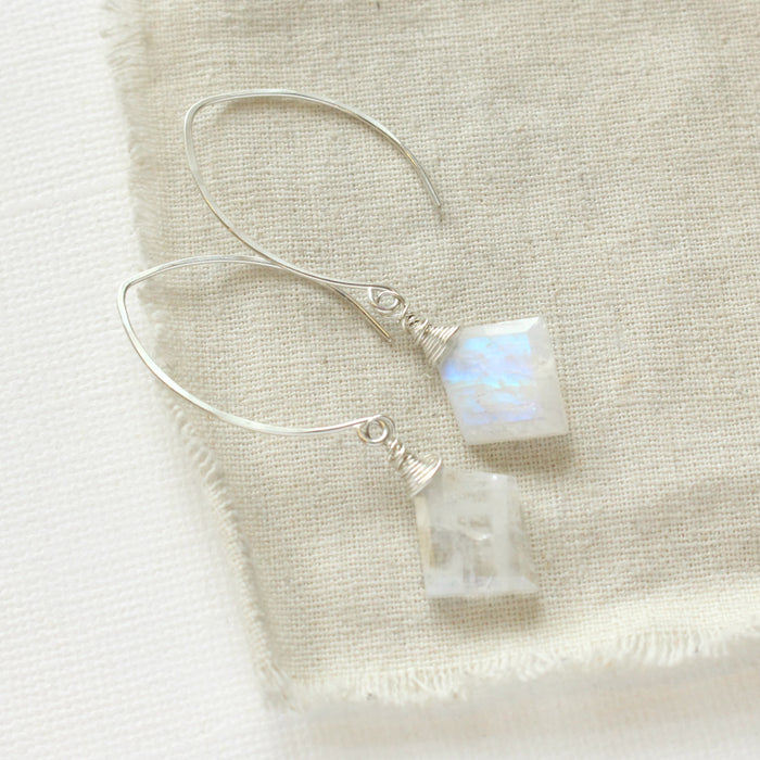 The moonstone slice petal earrings styled on tan linen