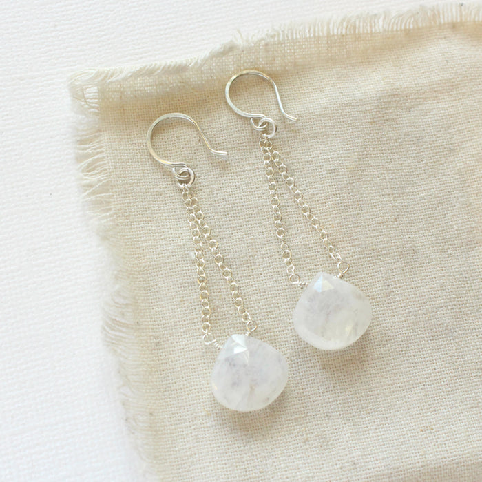 The moonstone swing earrings styled on tan linen