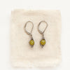 The silver wrapped olivine jade earrings styled on tan linen