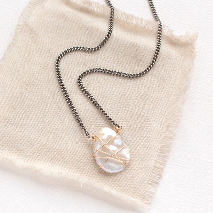 The organic pearl mixed metal necklace styled on tan linen