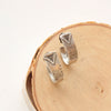 The pakal hoop post earrings styled on wood