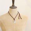 A mannequin wearing the pakal teardrop adjustable leather necklace in the short style