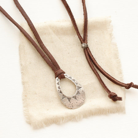 The pakal teardrop adjustable leather necklace styled on tan linen