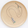 The pakal trio turquoise necklace styled on a tan plate to show the adjustable lobster clasp closure