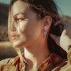 A model wearing the pakal trio turquoise post earrings