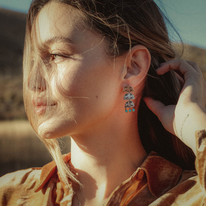 A model wearing the pakal trio turquoise post earrings