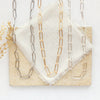All three options of the paperclip necklace styled on a tan rock with linen and dried grass