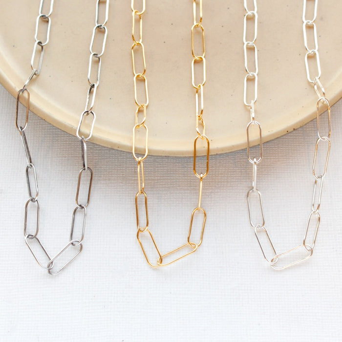 All three options of the paperclip necklace styled on a tan plate