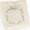 The pearl wrapped bracelet styled on tan linen