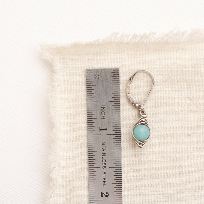 A wrapped amazonite earring next to a ruler for size reference