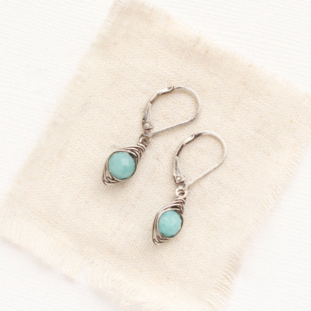 The wrapped amazonite earrings styled on tan linen