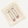 The phosphosiderite wrapped long hoop earrings styled on tan linen