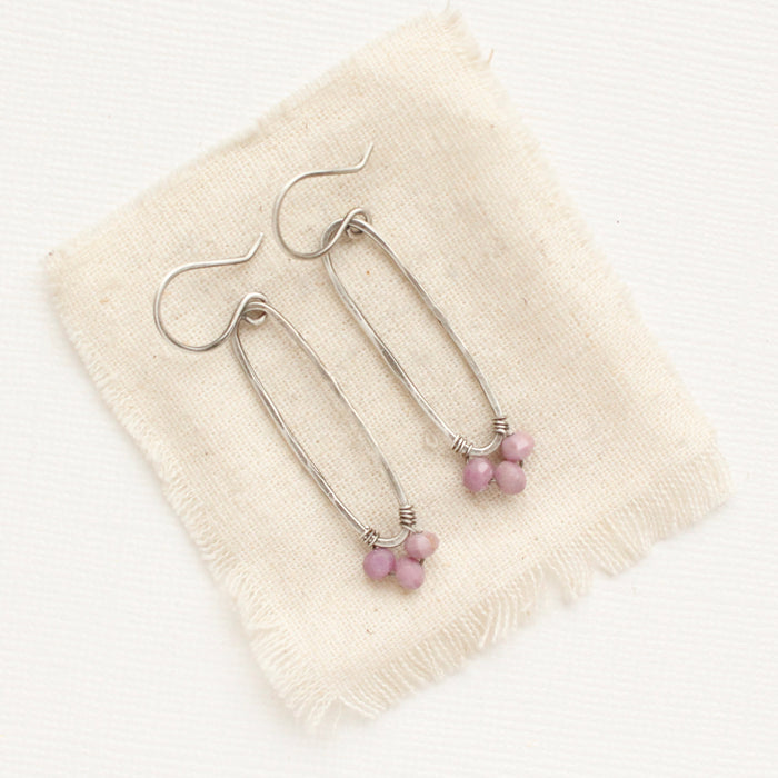 The phosphosiderite wrapped long hoop earrings styled on tan linen