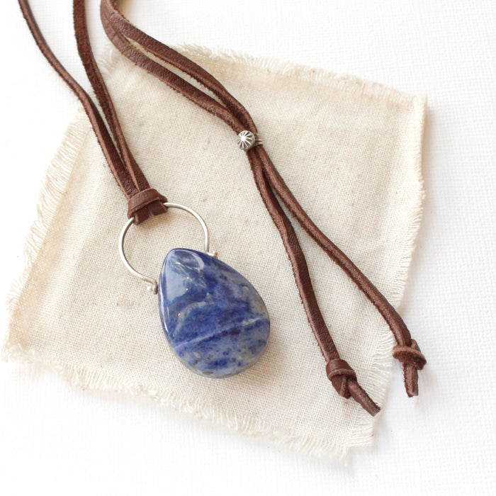 The pinned sodalite adjustable leather necklace styled on tan linen