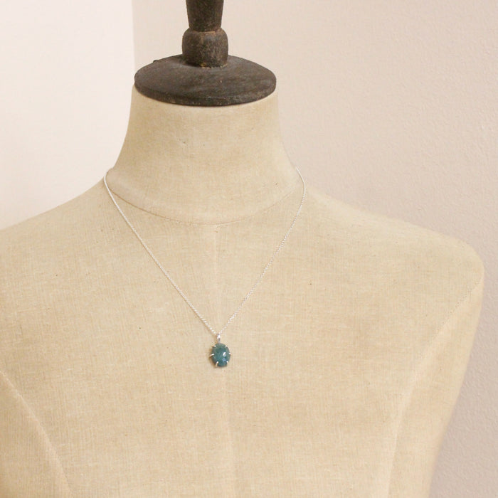 A mannequin wearing the prong set emerald necklace