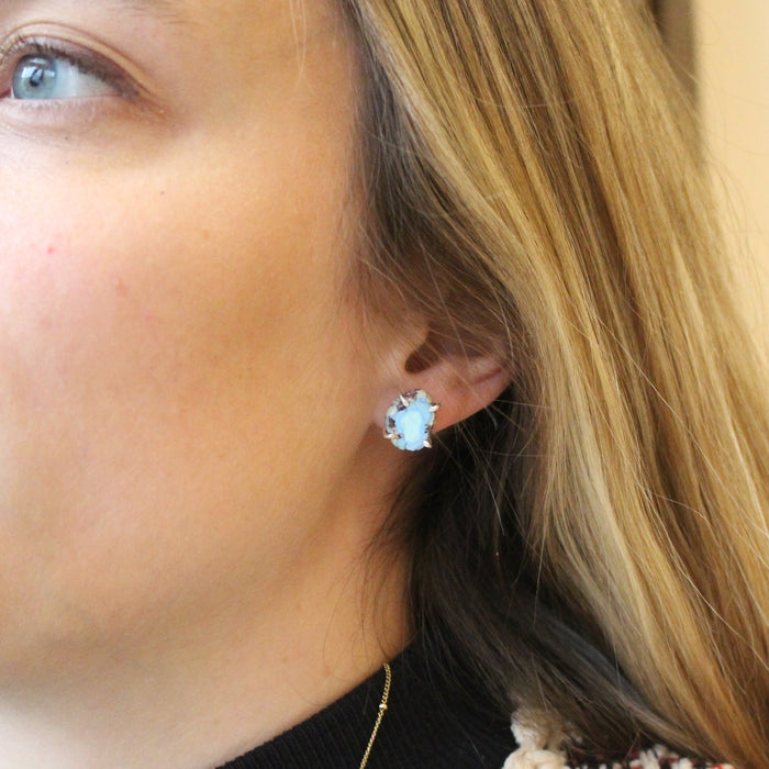 The lavender turquoise post earrings being worn in an ear to show size reference