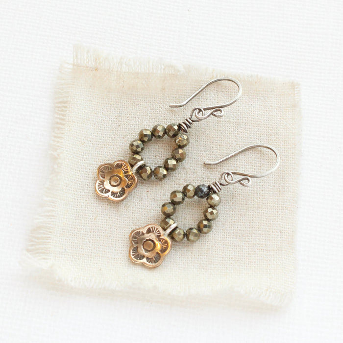 The mini bronze cactus flower & pyrite hoop earrings styled on tan linen