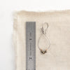 A pyrite wrapped teardrop hoop styled next to a ruler for size reference