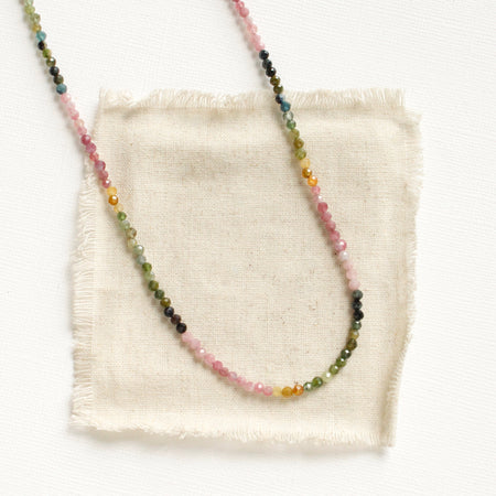 The rainbow tourmaline necklace styled on tan linen