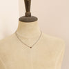 A mannequin wearing the little garnet drop necklace