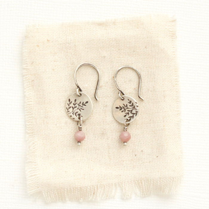 The rhodonite sprout earrings styled on tan linen