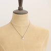 A mannequin wearing the rhodonite and sprout charm necklace