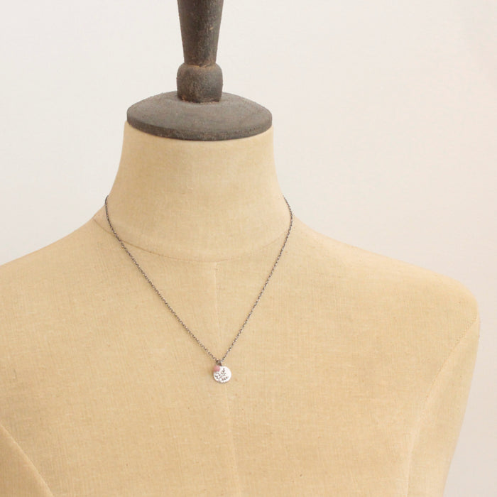 A mannequin wearing the rhodonite and sprout charm necklace
