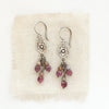 The mini cactus flower ruby and phosphosiderite earrings styled on tan linen