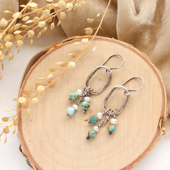 The seaside hoop earrings styled on wood with tan velvet and dried grass