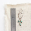A seaside hoop earring next to a ruler for size reference
