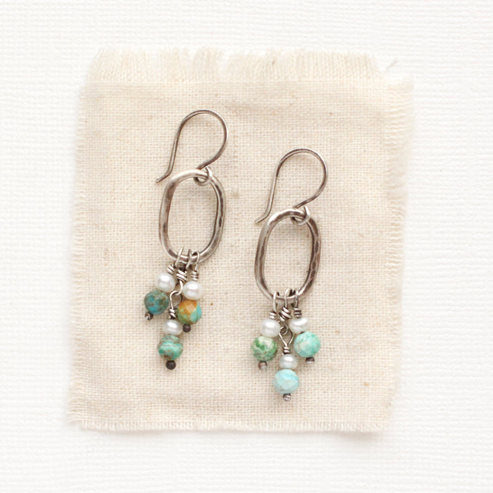 The seaside hoop earrings styled on tan linen
