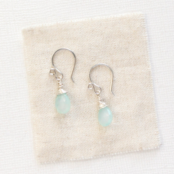 The chalcedony drop silver earrings styled on tan linen
