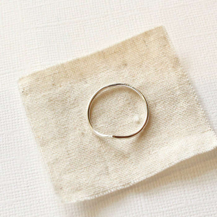 The silver momentum ring styled on tan linen to show the top view