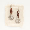 The silver wanderer coin leather earrings styled on tan linen