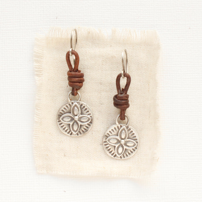 The silver wanderer coin leather earrings styled on tan linen