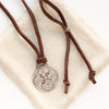 The silver wanderer medallion adjustable leather necklace styled on tan linen