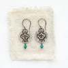 The layered soar amazonite earrings styled on tan linen