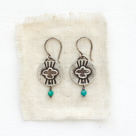 The layered soar amazonite earrings styled on tan linen