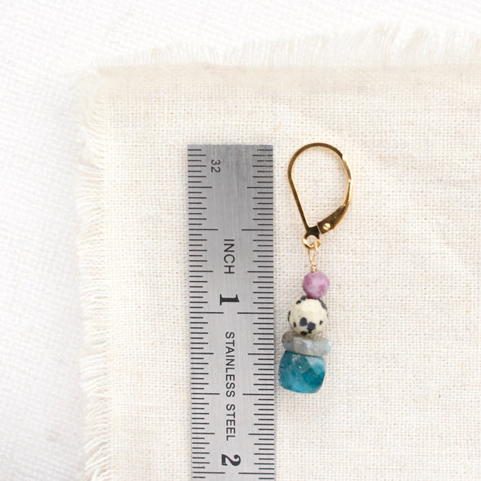 A stacked capri earring next to a ruler for size reference