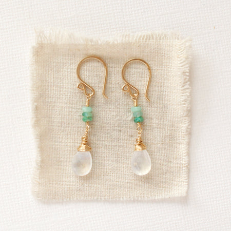The stacked emerald and moonstone drops styled on tan linen