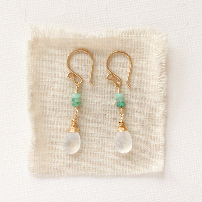 The stacked emerald and moonstone drops styled on tan linen