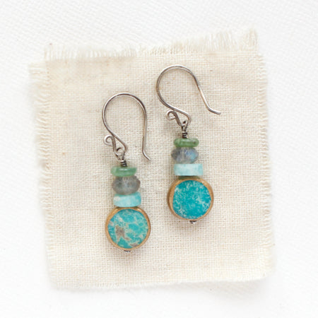 The stacked marin earrings styled on tan linen